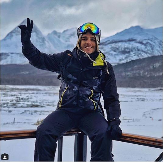 Fábio Beltrão em uma jornada pelo Ushuaia. Em segundo plano, o chão e as montanhas cobertas de neve completam a fotografia.